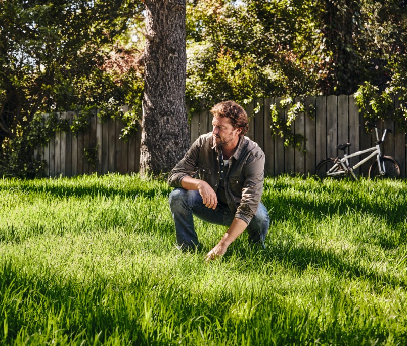 Un homme examine sa pelouse.